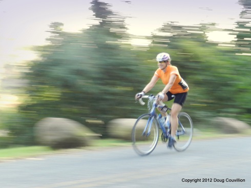 Photograph of a smiling woman cycling